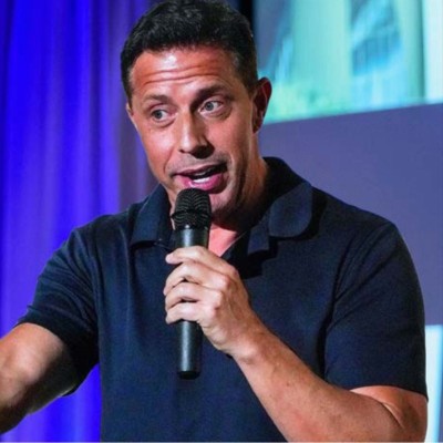 Aaron Bare delivering a keynote with a microphone on stage