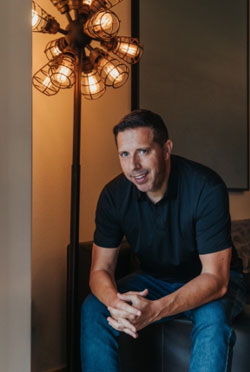 Aaron Bare seated in warm light